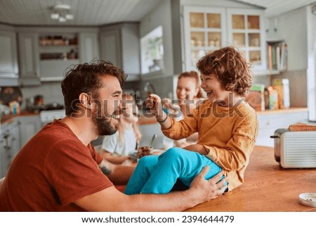 Cheerful family has fun during a meal at the dining table Royalty-Free Stock Photo #2394644479