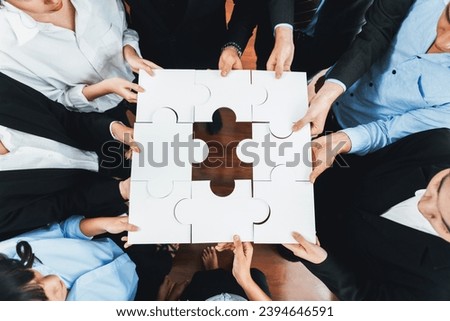 Top view multiethnic business people holding jigsaw pieces and merge them together as effective solution solving teamwork, shared vision and common goal combining diverse talent. Meticulous Royalty-Free Stock Photo #2394646591