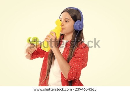 Teen hipster girl skater with skateboard water bottle and headphones on isolated background. Summer kids trend, urban teenage style.