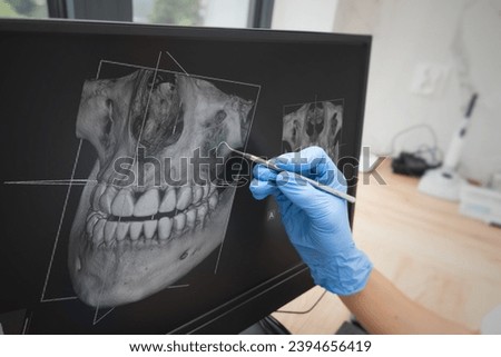 Dental consultation in clinic. Dentist showing teeth x-ray on digital tablet screen. 3D tomography technology.