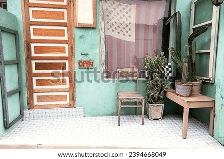 Old chair and cacti near front door of small vintage country store.