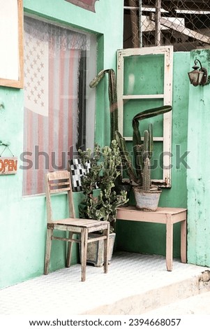 Old chair and cacti near front door of small vintage country store.
