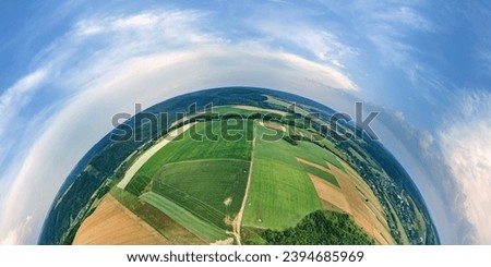 Aerial view from high altitude of little planet earth with green and yellow cultivated agricultural fields with growing crops on bright summer day Royalty-Free Stock Photo #2394685969