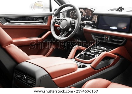 Interior of new modern SUV car with steering wheel, shift lever and dashboard, climate control, speedometer, display.  Red leather interior Royalty-Free Stock Photo #2394696159