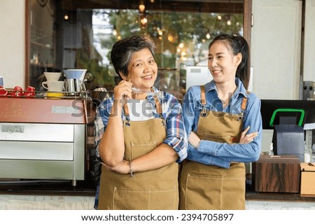 Lifestyle Asian elderly, healthy 60s mother, senior, pensioner, female standing with young barista waitress wearing apron uniform open cafe restaurant small business shop entrepreneur after retirement Royalty-Free Stock Photo #2394705897