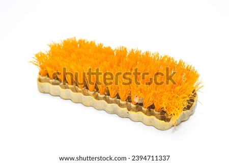 orange hand brush for clothes, which is worn and has been used for a long time on a white background. Royalty-Free Stock Photo #2394711337