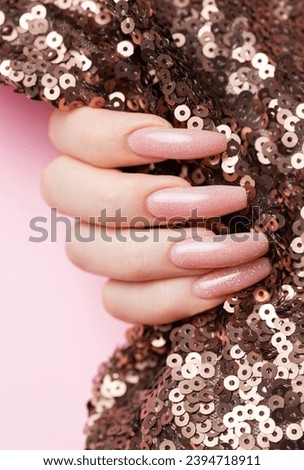 Female hands with beautiful manicure  on sequins background