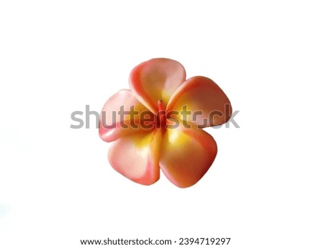 The white background in the picture is a candle in the shape of an orange and yellow frangipani flower. In the middle of the picture there is an orange wire that can be lit for use in festivals.

