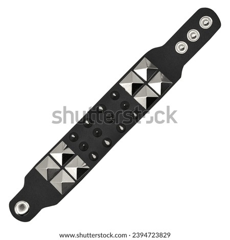 Black leather bracelet with spikes, pyramids. An accessory for rockers, bikers, metalheads, goths and punks. Steampunk style. Close-up subject photography. Royalty-Free Stock Photo #2394723829