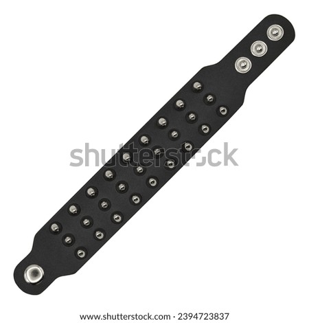 Black leather bracelet with spikes, pyramids. An accessory for rockers, bikers, metalheads, goths and punks. Steampunk style. Close-up subject photography. Royalty-Free Stock Photo #2394723837