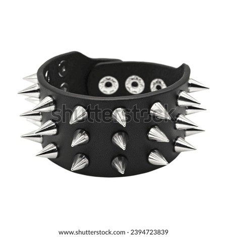 Black leather bracelet with spikes, pyramids. An accessory for rockers, bikers, metalheads, goths and punks. Steampunk style. Close-up subject photography. Royalty-Free Stock Photo #2394723839