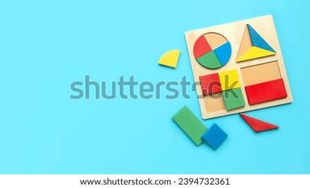 Educational toys, Cognitive skills, kid development logical thinking concept. Colorful geometric shapes toys over a blue background. Sorter for different shapes and color.