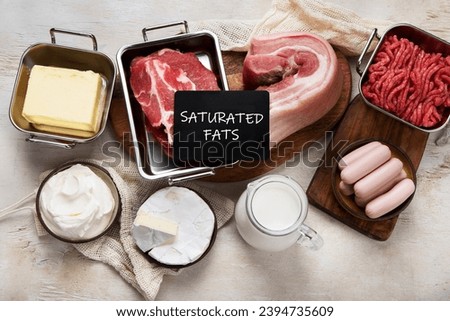 Saturated fats on tables. Raw meat, sausages, cheese, butter. Bad food concept. Top view Royalty-Free Stock Photo #2394735609