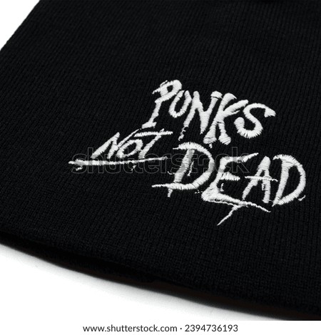 Black knitted cap with embroidered Punks not Dead inscription. Stylish accessory for parties and music festivals. Gift for rockers, punks, metalheads, bikers, goths.