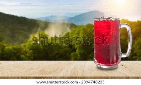 Fresh Roselle juice sweet water and iced in glass on wooden table with nature background, Summer health drinks with ice, Red juice with ice cubes in glass Royalty-Free Stock Photo #2394748235