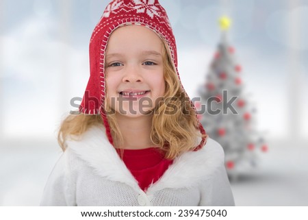 Cute girl in hat against blurry christmas tree in room