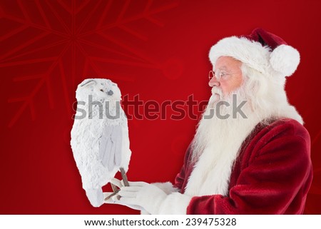 Father Christmas holds an owl against red background