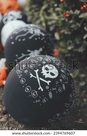 Halloween black balloons decorated in garden. Halloween party activity ideas
