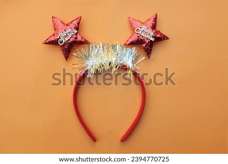 decorated Beautiful headband funny red star isolate on a orange backdrop.
concept of joyful Christmas party,New year is coming soon, festive season decoration with Christmas elements