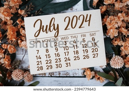 July 2024 monthly calendar with flower bouquet decoration  on wooden background