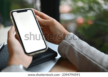 Closeup businesswoman using mobile phone at cafe. White empty screen for advertising text