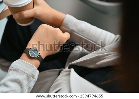 Cropped shot of young businesswoman in formal suit checking time on wrist watch for appointment