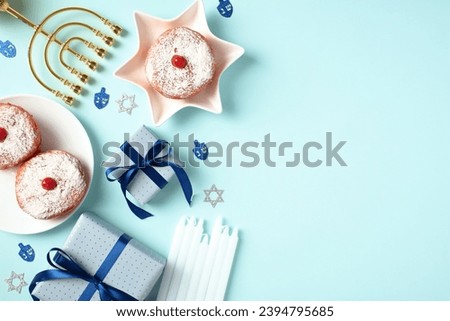 Hanukkah banner design. Flat lay composition with gift boxes, golden menorah, jelly donuts, candles on blue background.
