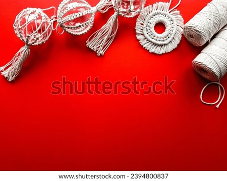Christmas decor using macrame technique. Christmas decorations on a red background. Natural materials - cotton thread, wooden beads and transparent balls for the Christmas tree. Eco decorations