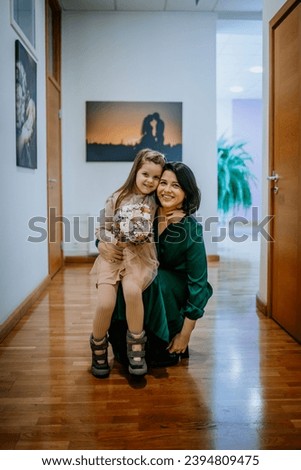 mother and daughter indoors, caressing each other