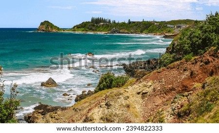 Australian coast with rocks on the seashore, view from the cliff of the seaside landscape with blue water on a summer sunny day.