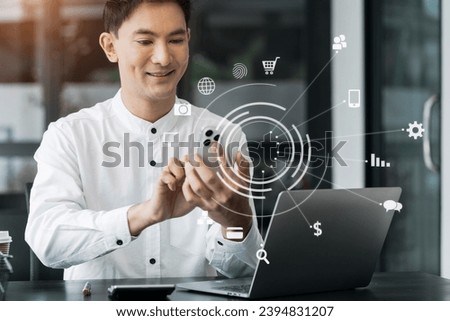 businessman using mobile phone with laptop and digital tablet laptop and document on desk in office with virtual icons network diagram in morning light.