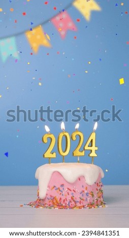 Happy New Year 2024, cute cake with golden candle number 2024 for new year celebrate party was lit with colorful confetti and bunting flag isolated on blue background, vertical