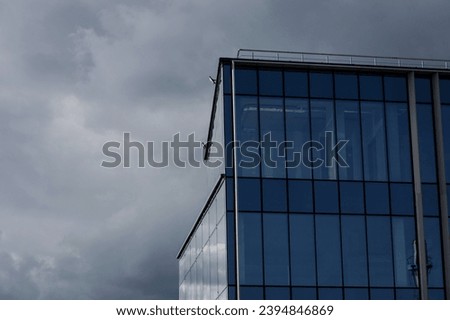  image of glass office building on gray sky background