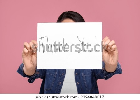 Woman holding card with phrase Thank You on pink background, selective focus