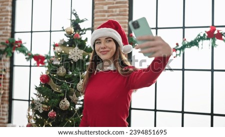 Young hispanic woman taking a selfie picture celebrating christmas at home