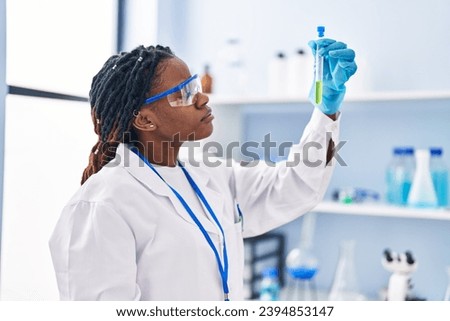 African american woman scientist holding test tube at laboratory Royalty-Free Stock Photo #2394853147