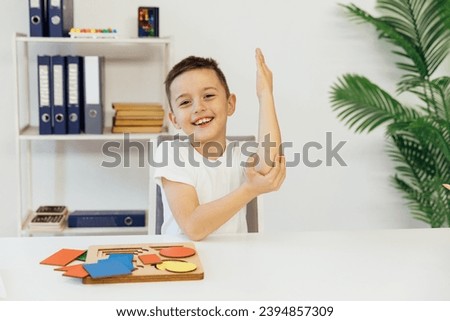 a boy in the office raises his hand in class