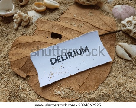 Delirium writing on beach sand background.