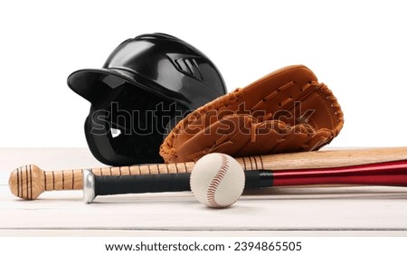Baseball glove, bats, ball and batting helmet on wooden table against white background