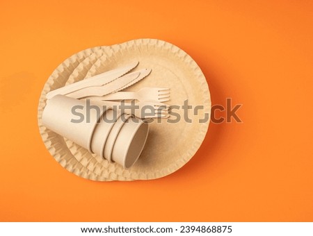 Paper Plate, Fork, Knife on Orange Background, Eco Tableware Set, Disposable Cutlery, Biodegradable, Eco Bio Table Setting for Picnic, Recycle Reusable Utensil on Color Background with Copy Space Royalty-Free Stock Photo #2394868875