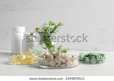 Different pills on white wooden table, space for text. Dietary supplements Royalty-Free Stock Photo #2394870521