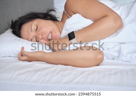 Subtle frown in slumber, indicative of nocturnal teeth grinding. A genuine moment touching on the prevalence of bruxism. Royalty-Free Stock Photo #2394875515