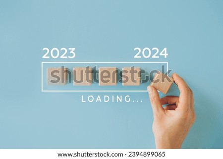 Female hand putting wooden cube for countdown to 2024. Loading year from 2023 to 2024. New year start concept Royalty-Free Stock Photo #2394899065