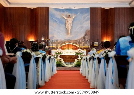 Inside large Christian church, picture of Jesus on the wall, and many people were attending religious ceremonies, a Sacred Christian Ceremony. Holy Communion, Divine Mass ,Guidance of the Bible