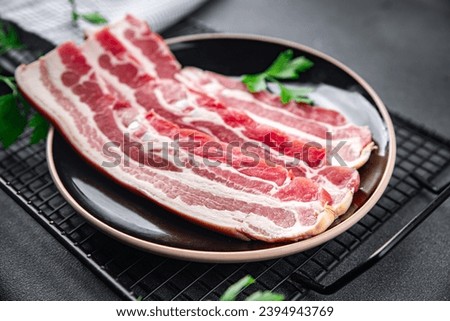 bacon slice fresh meat strips pork cooking appetizer meal food snack on the table copy space food background rustic top view Royalty-Free Stock Photo #2394943769