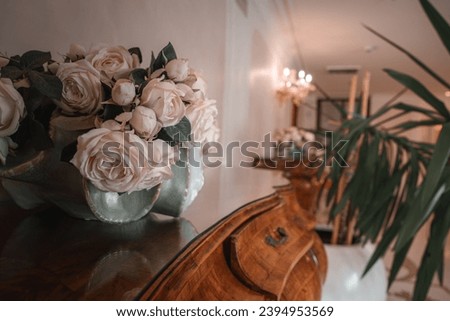 A beautiful vase of roses on a brown dresser in Venice, Italy. The flowers are casually arranged with no other decor in sight.