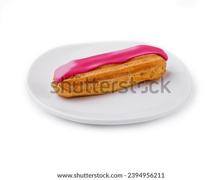 Eclair dessert with pink icing on plate Royalty-Free Stock Photo #2394956211