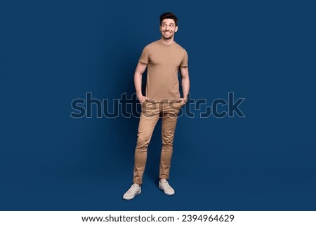 Full length photo of cheerful funny man wear beige outfit look at sale empty space arms in pockets isolated on dark blue background