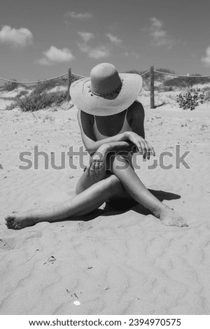 girl takes a photo on the beach in hat, there is a place for an inscription,photo is black and white