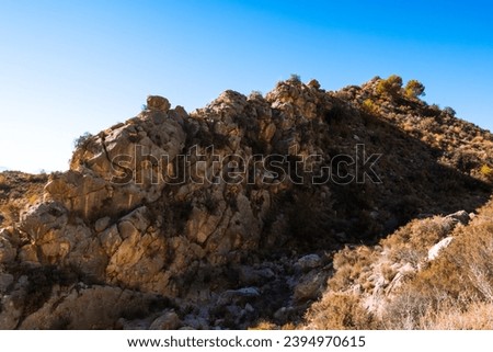close up isolated photo of rich golden geometric mountain wall against blue sky for abstract